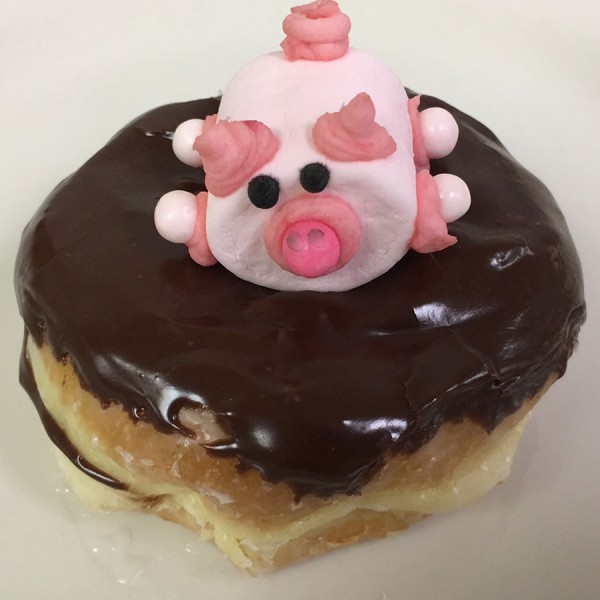 Pig-in-Mud-donut-which-is-a-raised-donut-filled-with-Colorado-Creme-(commonly-known-as-Bavarian-Creme),-chocolate-frosting-and-a-decorated-pink-marshmallow-pig-on-top